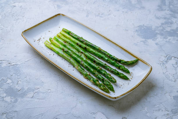 istock Asparagus grill on plate on white concrete table 1414282893
