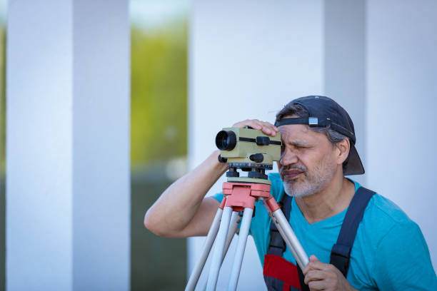 istock A man works with an optical level to level the landscape. 1414283879