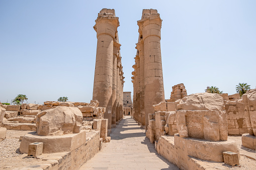 A beautiful scene featuring a grand building, with several large statues of people standing in front of it