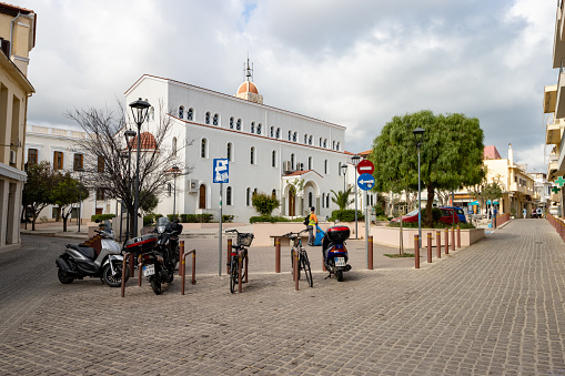 Church of the Great Panagia in Rethymnon on Crete, Greece, with people and number plates visible.