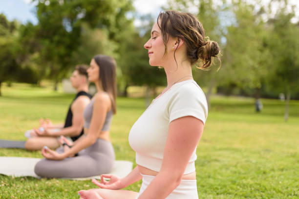 meditieren mit freunden im park - good posture yogaclass lifestyles sport stock-fotos und bilder