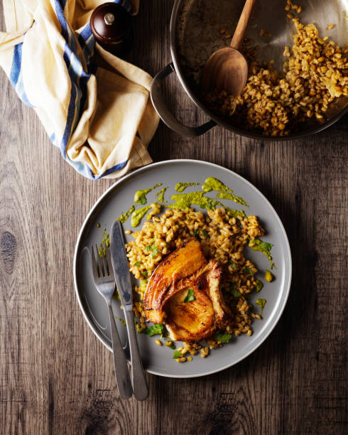 pork chop with barley grains risotto and fine chimichurri sauce stock photo