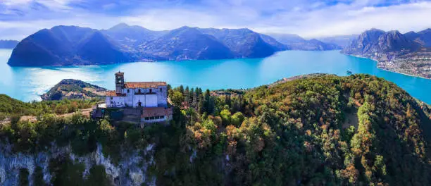 Photo of Italian lakes scenery. Amazing Iseo lake aerial drone view.  one of the most beautiful places - Shrine of Madonna della Ceriola in Monte Isola - scenic island in the moddle of lake. Italy travel destinations and landmarks