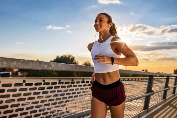 istock Young Smiling Woman Running Outdoors at Sunset 1414287456