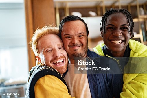 istock Portrait of a disabled young man and his friends embraced at home 1414287472