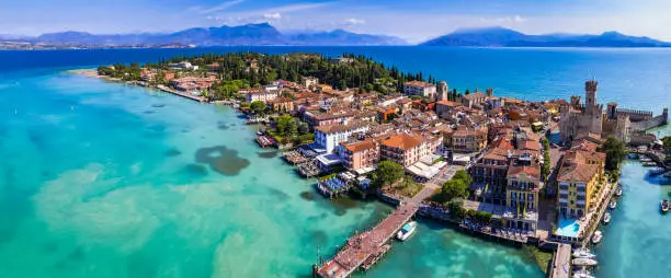 Photo of Scenic lake Lago di Garda aerial drone view of Sirmione town and medieval castle Scaligero. Italy, Lombardy