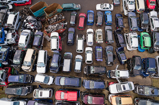 Aerial view of a junkyard full of wrecked cars stacked one on top of the other.