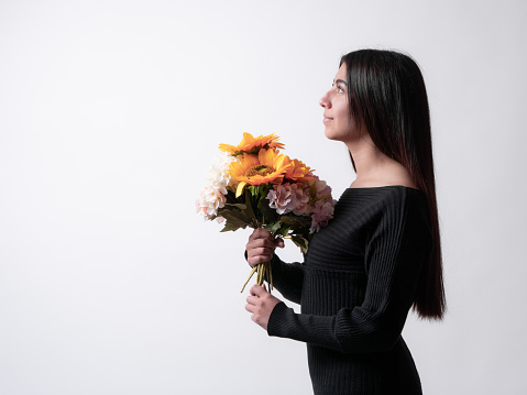 beautiful latina girl holding a bouquet of sunflowers, isolated on white background, mother's day gift concept.