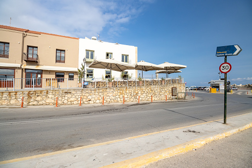 A woman looks out over a Directional Sign to Custom House at Rethymnon on Crete, Greece