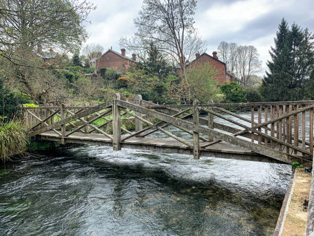 Wooden bridge over Itchen river. Houses in Winchester by the river Itchen Wooden bridge over Itchen river in Winchester, Hampshire, England, UK. wharfe river photos stock pictures, royalty-free photos & images