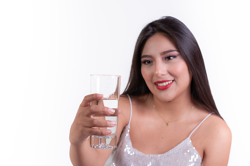 latina woman holding a glass of water, ready to drink, hydration concept, how water helps to stay young and beautiful