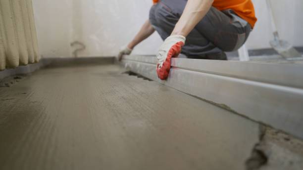Production of cement floor. Floor screed in the apartment. Leveling the floor screed with metal wire. stock photo