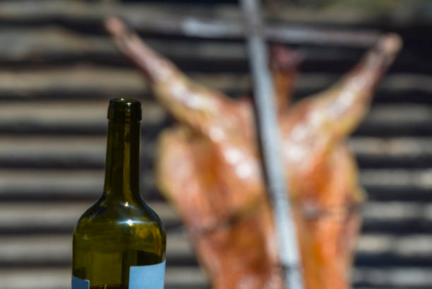 Bottle of wine with roast lamb in the background