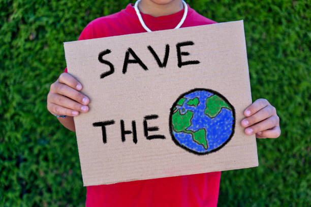 istock Small child holding placard poster save the planet 1414299247
