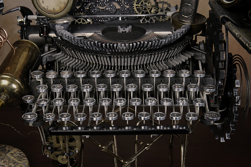 old retro vintage typewriter on wooden table, with paper, laser, wheels, letters, hat, and light lens