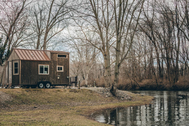 Tiny Home Living A tiny home and tree reflection in a pond in New England. tiny house stock pictures, royalty-free photos & images
