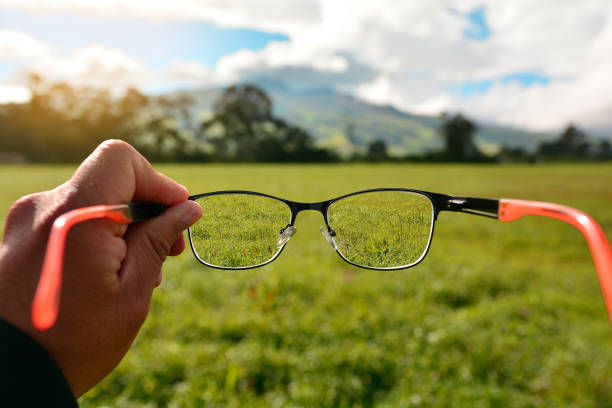 istock hand holding lenses showing a person's focus and myopia, seeing nature 1414306081