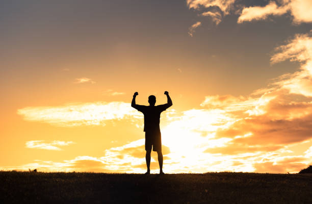 istock Men flexing muscles at sunset. Winner. 1414308147