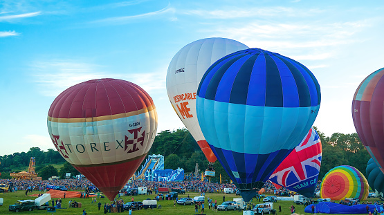 Bristol, UK - August 13, 2016: The Bristol International Balloon Fiesta 2016, showing the mass ascent and landings of over 100 balloons including special shapes and the 'night glow', where the burners are used at night to illuminate the balloons. This annual event takes place in Ashton Park, Bristol.