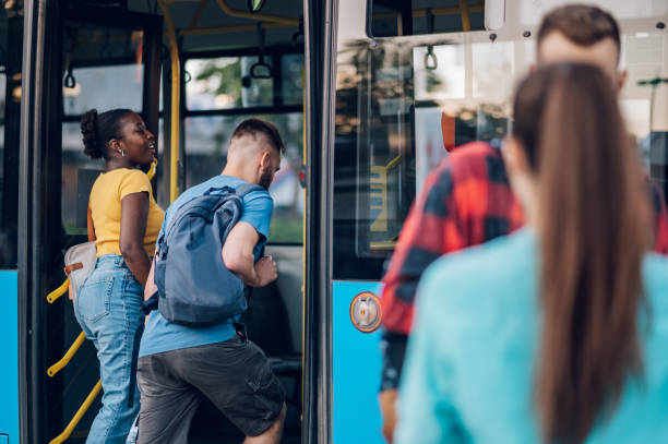 istock Multiracial friends entering a public transport at a bus stop 1414309216