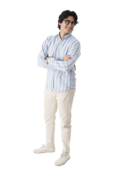 Full shot of a cheerful young latin men standing with him arms crossed, looking away  and smiling.