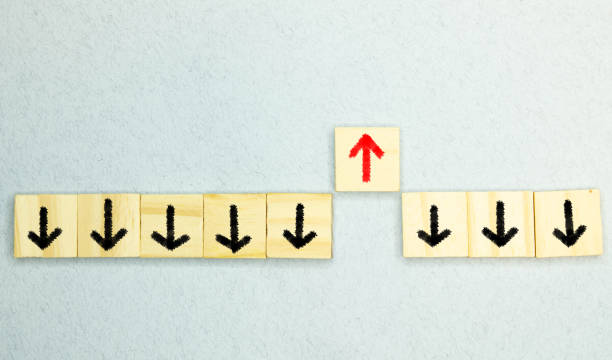 istock Wooden block with red arrow facing the opposite direction black arrows, Unique, think different 1414314454