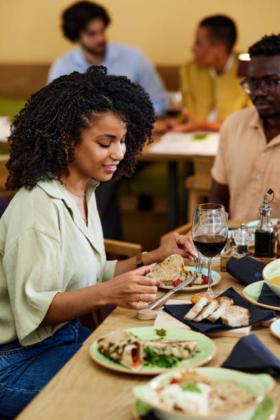 istock A hungry Hispanic girl is eating dinner at the restaurant. 1414314492