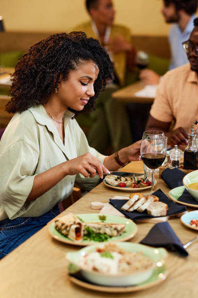 istock A hungry Hispanic girl is eating dinner at the restaurant. 1414314504