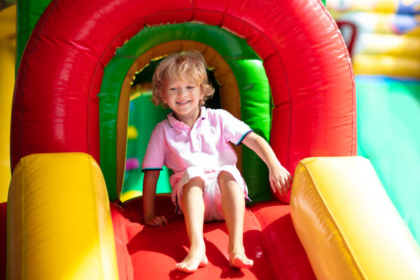 istock Child jumping on playground trampoline. Kids jump. 1414314530