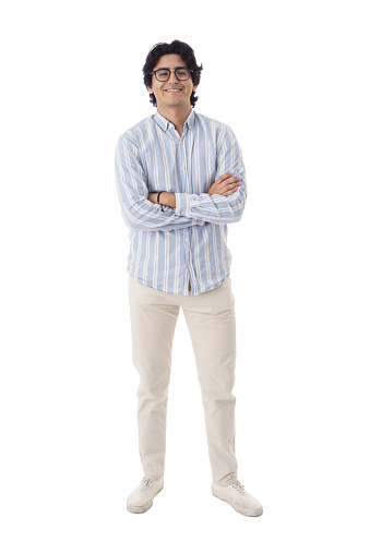 An attractive man in his 20s wearing a blue shirt  and eyeglasses standing with his arms crossed against a white background. full body