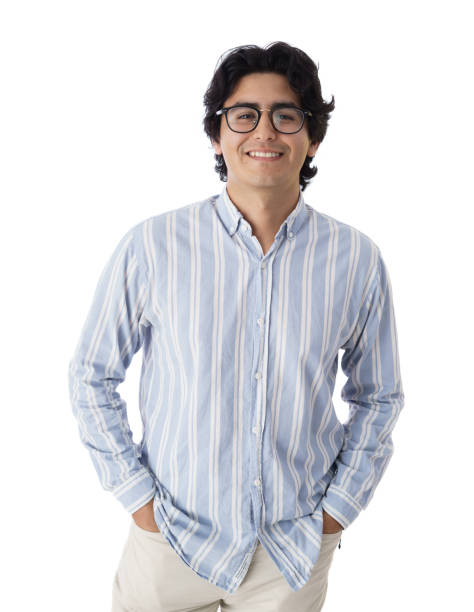 A happy young latin man standing with his hands in her pockets and smiling at the camera.