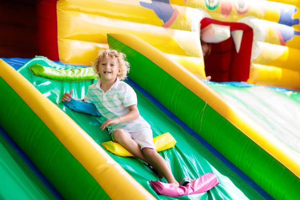 istock Child jumping on playground trampoline. Kids jump. 1414317165