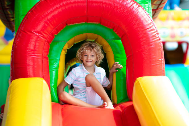 istock Child jumping on playground trampoline. Kids jump. 1414317174