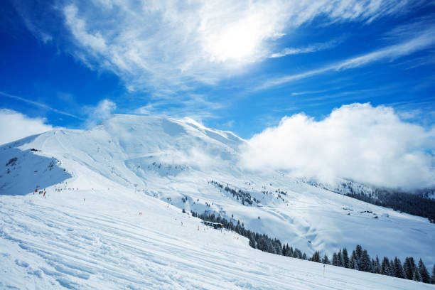 View of the mountain range and valley covered with snow on sunny day, French Alps ski resort