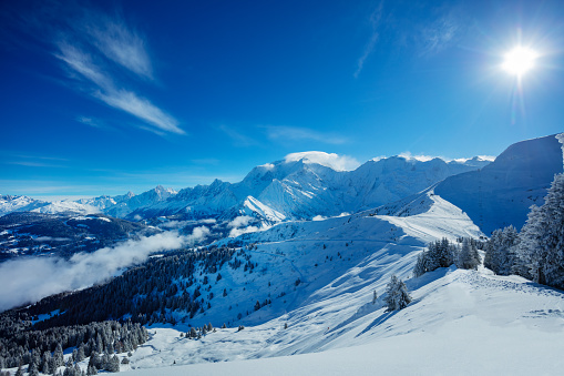 Panorama of French Alps at winter with snow coved slopes and peaks of Mont Blanc, bight sunny day