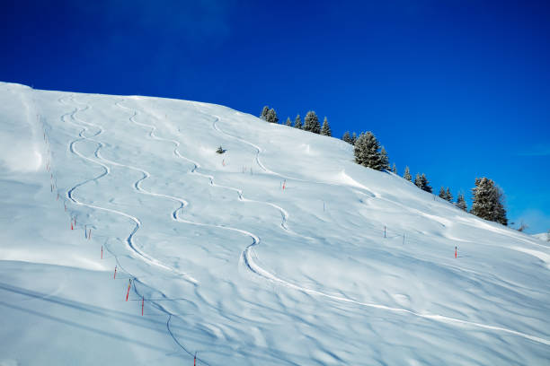 istock Traces from off-piste snowboarding on a mountain over blue sky 1414317658