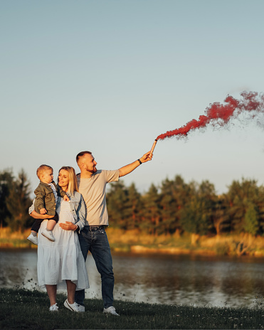 It's a Girl, Young Family, Mother and Father with Little Son Taking Baby Gender Reveal of Their Next Child by Smoke Bomb