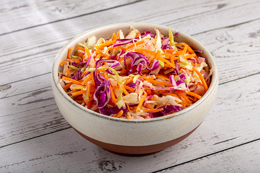 Coleslaw salad with white cabbage, red cabbage and sliced carrots.