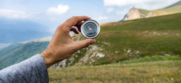 istock A male is looking for a compass in the mountains 1414322231