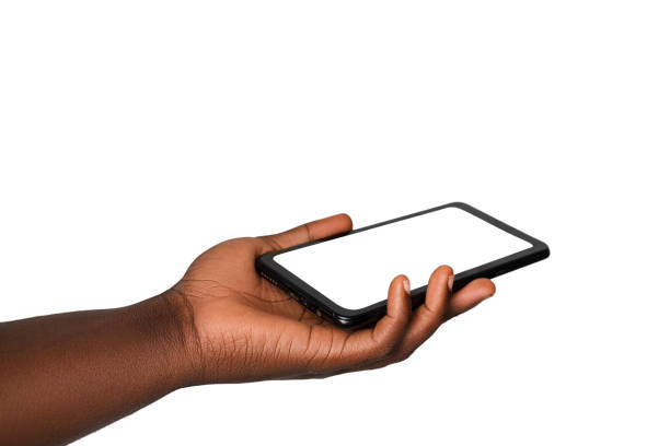 istock Black hand holding phone facing camera isolated on white background. blank screen, phone screen mockup, front view, clipping path, clipping mask 1414324031