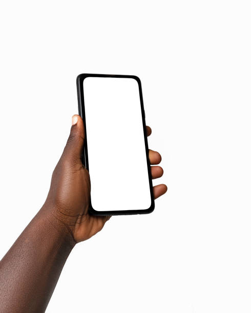 istock Black hand holding phone facing camera isolated on white background. blank screen, phone screen mockup, front view, clipping path, clipping mask 1414324074