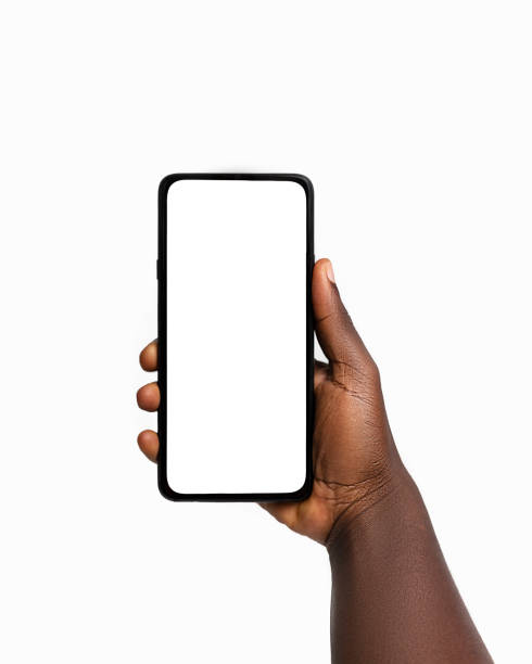 istock Black hand holding phone facing camera isolated on white background. blank screen, phone screen mockup, front view, clipping path, clipping mask 1414324083