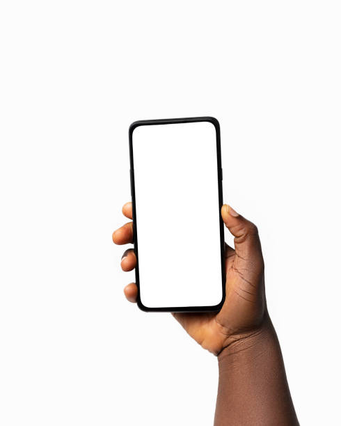 istock Black hand holding phone facing camera isolated on white background. blank screen, phone screen mockup, front view, clipping path, clipping mask 1414324088