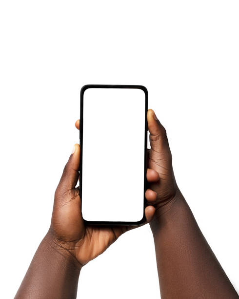 istock Black hand holding phone facing camera isolated on white background. blank screen, phone screen mockup, front view, clipping path, clipping mask 1414324094