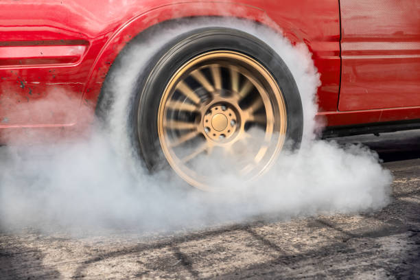 arrastre el neumático quemado del coche de carreras en la línea de salida en la pista de carreras - snowdrift fotografías e imágenes de stock