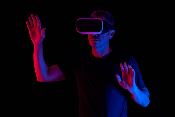 istock MAN WEARING VIRTUAL REALITY GLASSES ON DARK BACKGROUND. DEVELOPMENT OF NEW TECHNOLOGIES. METAVERSE CONCEPT. 1414332873