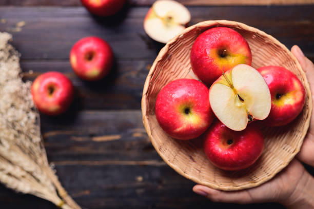 istock Red apple fruit in basket holding by hand 1414338908