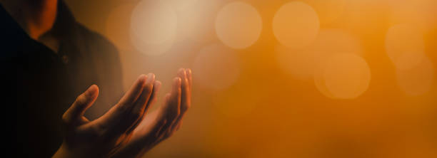 hand praying on orange light bokeh background. - miracle food imagens e fotografias de stock