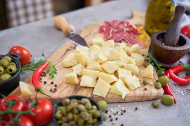 istock Chopped Parmesan cheese and vegetables on grey table at domestic kitchen 1414347794