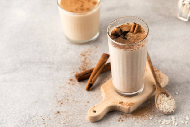 Cold drink based on Horchata rice in a glass on a wooden board with cinnamon sticks on a light background. Cold drink based on Horchata rice in a glass on a wooden board with cinnamon sticks on a light background.Vegetarian soft drink, national cuisine. sedge stock pictures, royalty-free photos & images